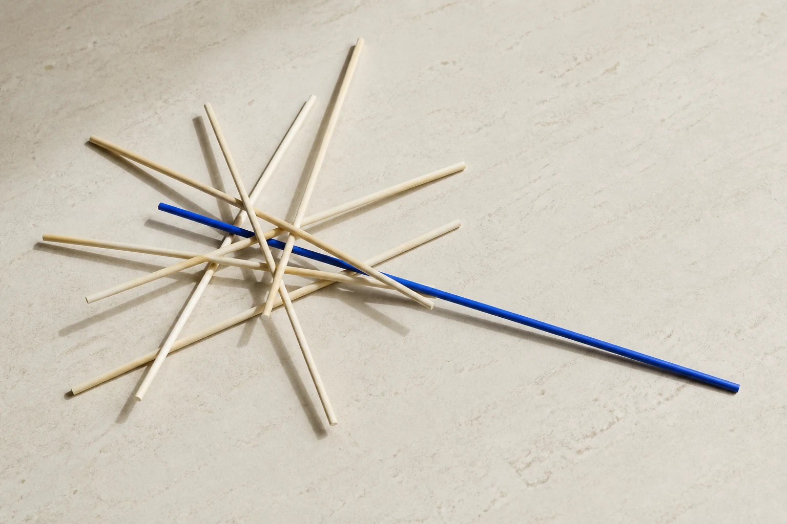 Geordnete helle Mikadostäbe mit einem einzelnen tiefblauen Stab als Sinnbild einer klaren Entscheidung